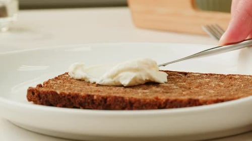 Cream Cheese Being Spread On Slice Of Bread