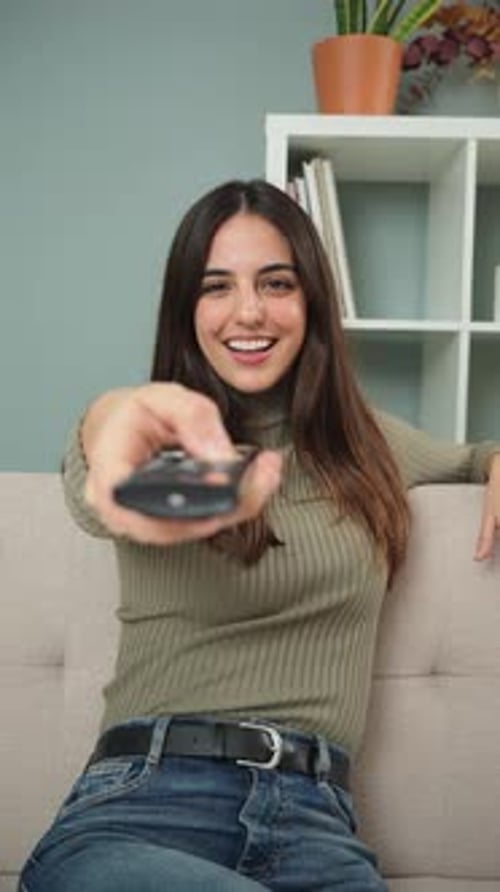 Vertical Young Woman Using the Television Remote Controller to Change the Channel Adult Caucasian