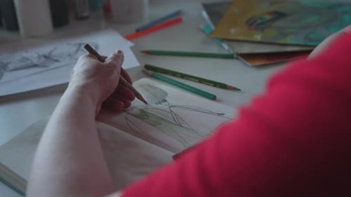 Artist Drawing in Studio Space on Artwork Surrounded by Artist'S Tools, Pencils,