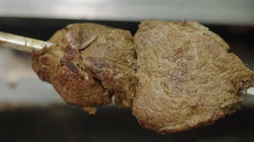 Rotating fried meat on a skewers. shashlik or Shish Kebab. close-up.Cooking juicy pork meat on metal