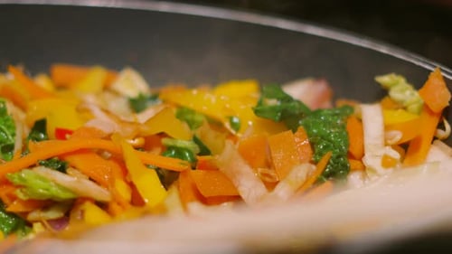 Side View of Steaming Very Hot Stir Fry Vegetables in Wok Pan with Shallow Depth of Field 4K
