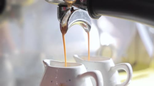 Close Up of Coffee Pouring into Pitchers