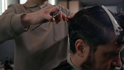 Professioneller Friseur, der mit Kunden im Barbershop zusammenarbeitet
