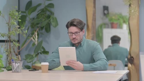 Man Using Tablet at Desk Indoors