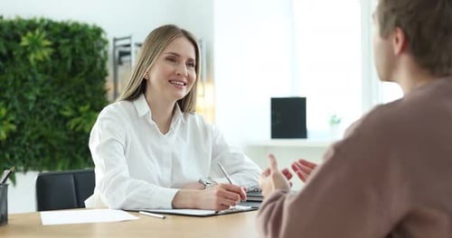 Recruteur souriant et candidat ayant un entretien d'embauche à table au bureau