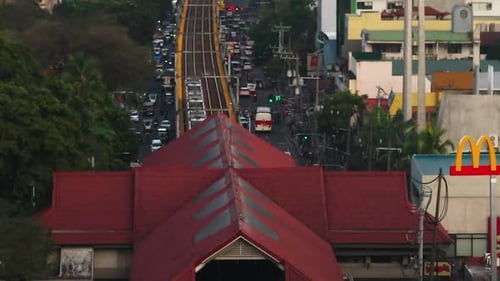 Elevated Train Line Above a Busy Street in Manila Vehicles and Pedestrians Move Through the Bustling