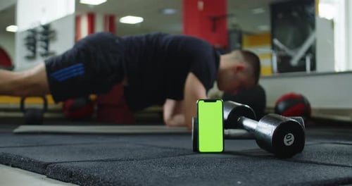 A Video Featuring a Green Screen Smartphone and a Man Doing Ab Exercises in the Background