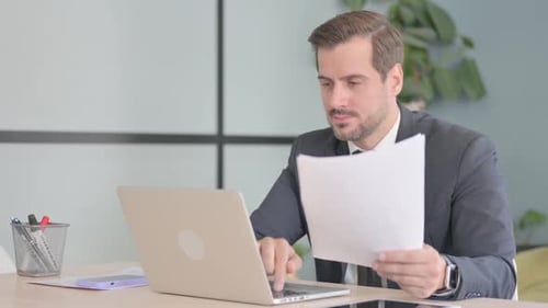 Man Typing on Laptop in Corporate Office