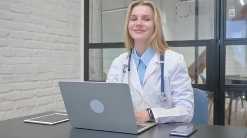 Doctor Types on Laptop in Modern Office