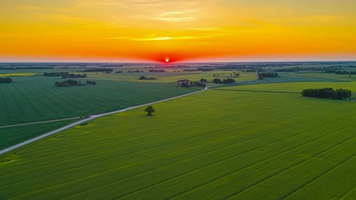 Aerial Timelapse of the evening sun dissapearing behind the horizon and rural fields