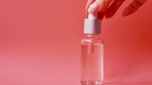Cosmetic Dropper Bottle on Pink Background