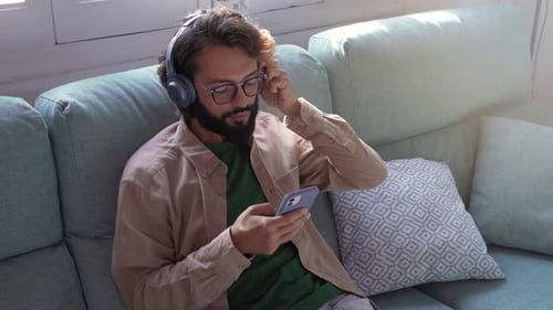 Young Man Listening to Music on Couch