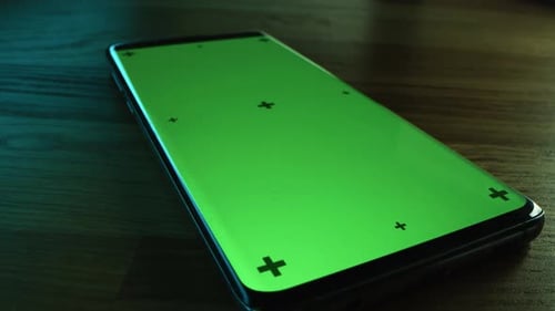 Makroaufnahme in Nahaufnahme mit Kamera, die über ein modernes Smartphone mit grünem Modellbildschirm fliegt. Mobil