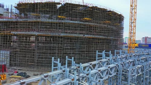 Piezas de carcasa de acero preparadas y grúa cerca de un estadio deportivo