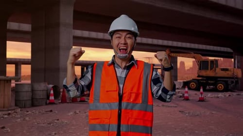Asian Male Engineer Screaming Goal Celebrating Working At Building Site