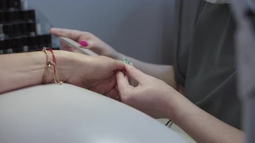 Manicurist Filing Nails in Beauty Salon