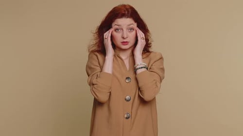 Red-Haired Woman Massages Temples and Face