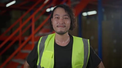Cheerful warehouse worker wearing a reflective safety vest
