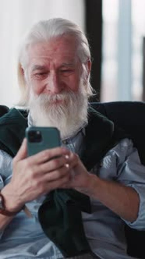 Senior Man Uses Phone for Video Chat