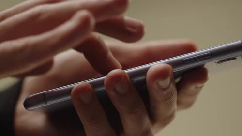 Cropped View of Male Hands Tapping on Smartphone Screen A Man Looks Through the News on His