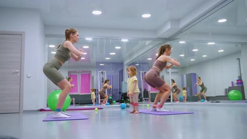 Women Exercising in Fitness Studio with Young Child