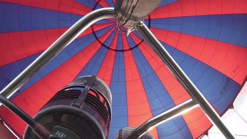 Inflating hot air balloon, close-up of flames and burner during flight
