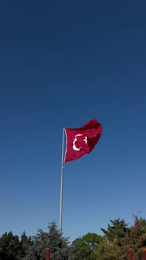 Turkish Flag Waving in the Wind Against Blue Sky