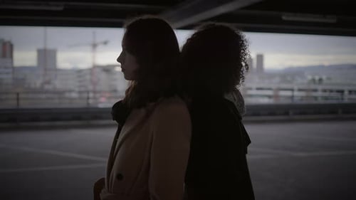 Lifestyle Portrait of Two Young Women Watching Tower Building Together