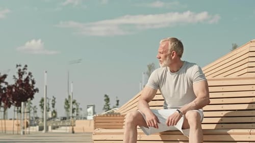 Mature Man Resting on Urban Bench