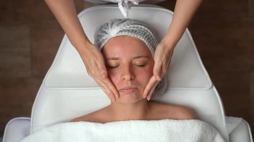 Woman Receives Relaxing Facial Massage in Beauty Salon