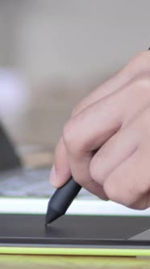 Man's Hand Using a Digital Pen on Tablet