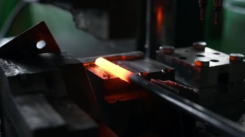 Herstellung der Form mit einer automatischen Maschine. Nahaufnahme des erhitzten Metallstabs in der Fabrik
