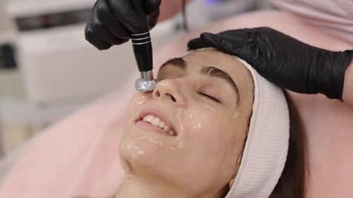 Young Woman Receives Facial Treatment at Medical Spa