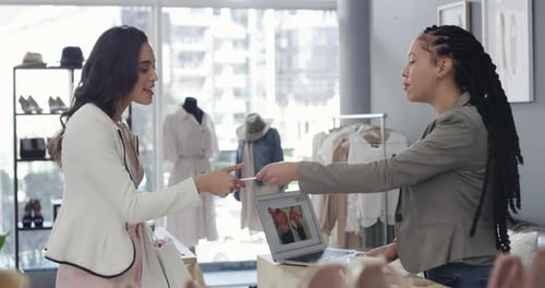 4k video footage of a young woman paying for goods with a credit card at a clothing store
