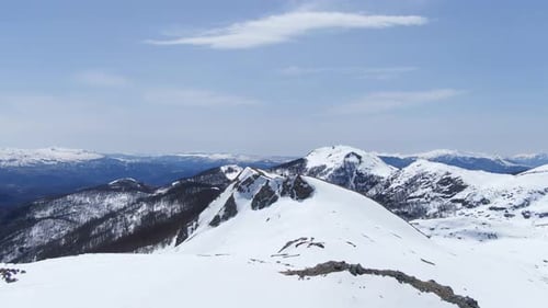 Cumbres montañosas cubiertas de nieve bajo un cielo azul claro Impresionante paisaje aéreo invernal