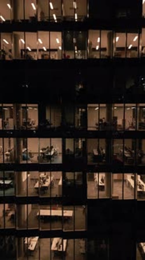 Aerial View of an Office Building with Illuminated Empty Offices at Night