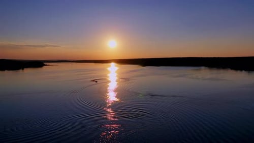 Beautiful sunset in nature. Sunny path reflects on the river in the evening.