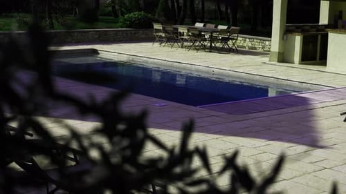 Swimming pool at dusk with outdoor furniture