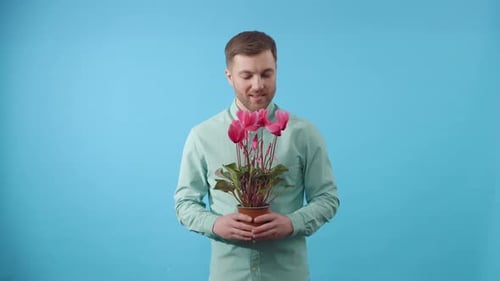 Man holding potted plant against blue background