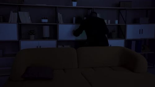 Man with Flashlight Searching in a Dark Room