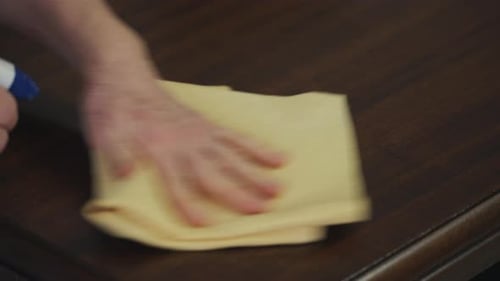 Spraying and Cleaning Dark Wood Table Close Up