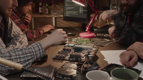 Computer Engineers Working with Motherboards in Workshop