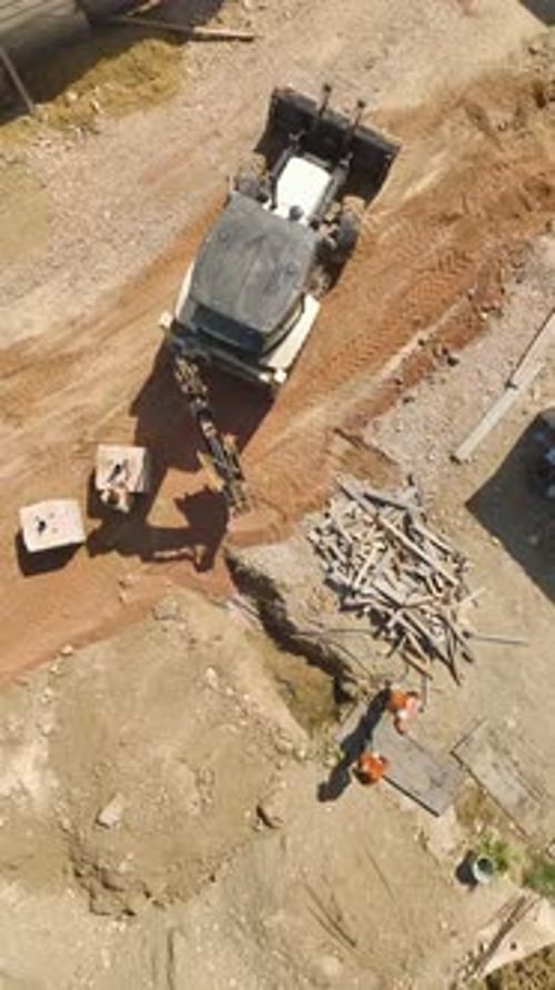 Vertical Video Groundwork Progress Aerial Gaze at Tractor Preparing Land for Housing Complex