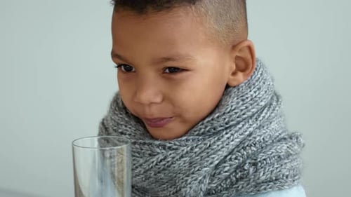 Boy Drinks Water, Wearing Scarf for Warmth