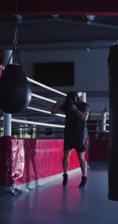 Boxermann beim Schattenkampftraining in einer dunklen Boxhalle