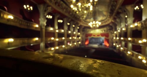 Elegante interior de teatro con detalles ornamentados e iluminación cálida para un evento nocturno