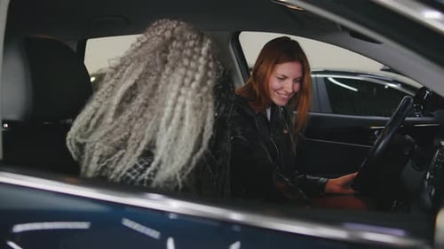 Women Inspecting New Car with Cheerful Salesman