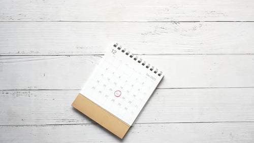 Calendars Falling onto White Wooden Background