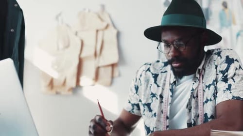 Designer sketching fashion at desk in studio