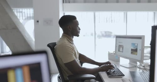 Male Graphic Designer Working At Computer In Office